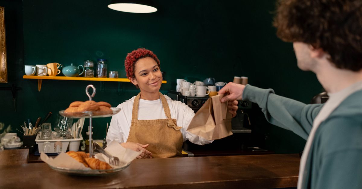 Aumentare lo scontrino medio — un barista propone un dolce al cliente al banco